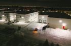 A team of Black Swan Landscaping workers operating a snow blower on a commercial property in Vaughan, Ontario, demonstrating professional snow management during a heavy snowstorm.