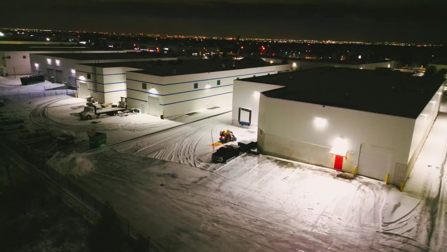 A bird's-eye view of a snowstorm being handled on a commercial property by Black Swan Landscaping's snow management team in Caledon, Ontario.