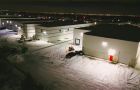 A bird's-eye view of a snowstorm being handled on a commercial property by Black Swan Landscaping's snow management team in Caledon, Ontario.