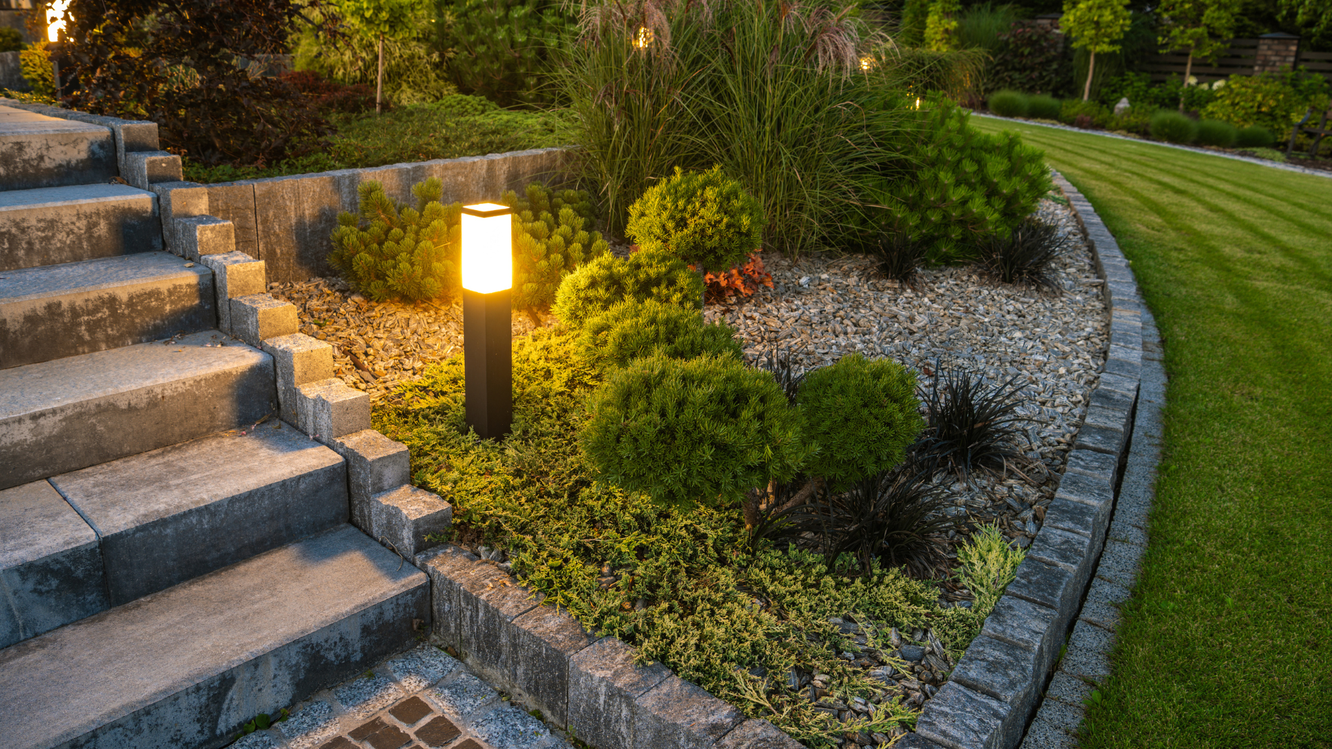 A light fixture illuminating a walkway and garden